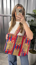 Person holding a colorful patterned bag outdoors